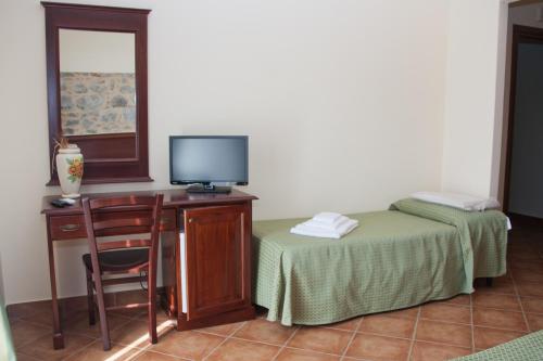 a room with a desk with a tv and a chair at Agriturismo Valle dell'Etna in Roccella Valdemone