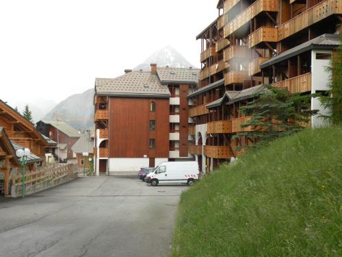 a white van parked in a parking lot next to a building at Au Coeur De La Station in Les Deux Alpes