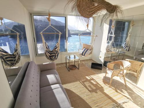 uma sala de estar com um sofá e algumas janelas em Tenerife Stay Ocean front II em Icod de los Vinos