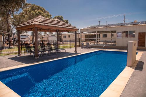 a swimming pool with a gazebo next to a building at Ceduna Foreshore Caravan Park in Ceduna