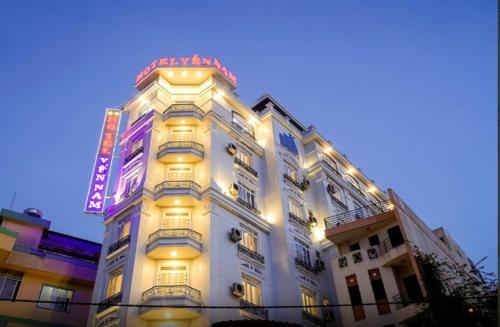 een wit gebouw met een neonbord erop bij Yen Nam Hotel Nguyen Trong Tuyen in Ho Chi Minh-stad