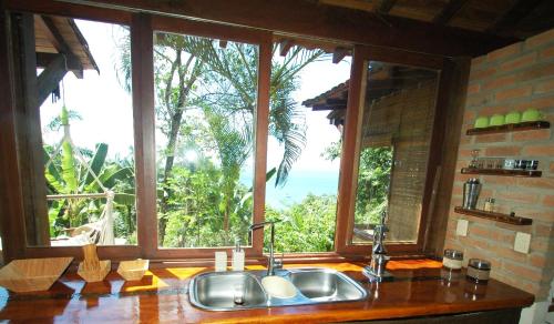 eine Küche mit einem Waschbecken und einem großen Fenster in der Unterkunft Casa Vista al Mar in Morro de São Paulo