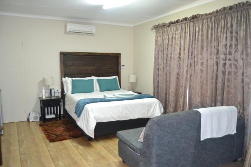 a bedroom with a bed and a couch at Green Grove Villa in Centurion