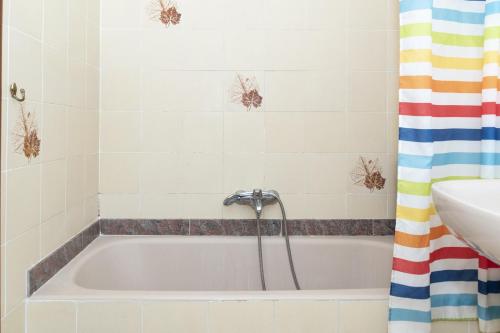 a bathroom with a bath tub with a shower curtain at Nereo, 10º-45 in Cullera