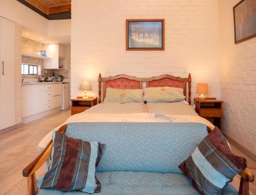 a bedroom with a large bed and two night stands at Nature on the HIll in Harare