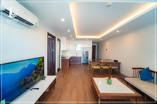 a living room with a large television and a table at D'Lioro Hotel & Resort in Ha Long