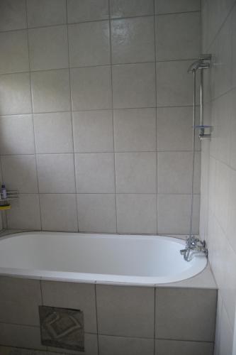a bath tub with a faucet in a bathroom at Green Grove Villa in Centurion