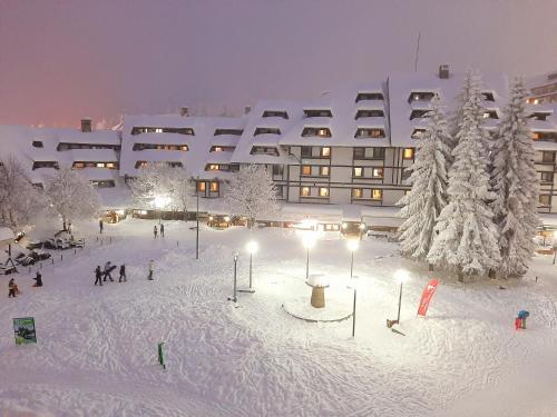 een groot gebouw met sneeuw bedekte bomen ervoor bij Select Lux Angella-Konaci in Kopaonik