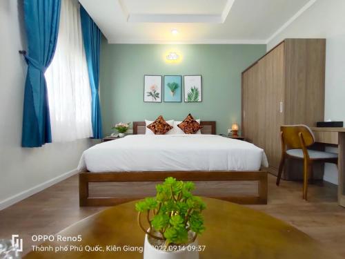 a bedroom with a large bed and a table at V&T Hotel Phu Quoc - 3 minutes to Beach in Phú Quốc