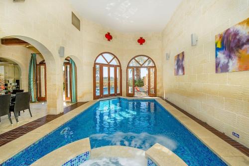 a large swimming pool in a room with at The Hamlet 2 Holiday Home in Għasri