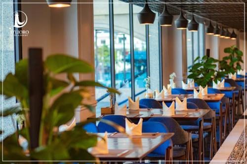 a restaurant with blue chairs and tables and windows at D'Lioro Hotel & Resort in Ha Long