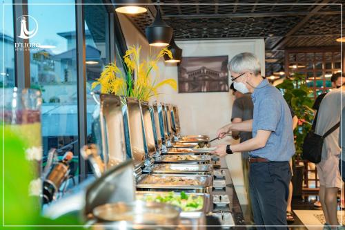 a man standing at a buffet line with food at D'Lioro Hotel & Resort in Ha Long