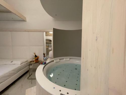 a bath tub in the middle of a room with a bed at Suite Albatros - Luxury Room in Bisceglie