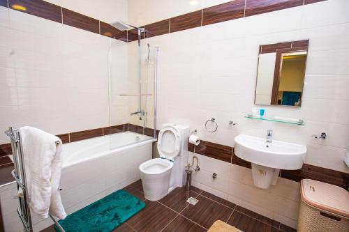 a bathroom with a sink and a toilet and a tub at Qlets Privé in Abuja