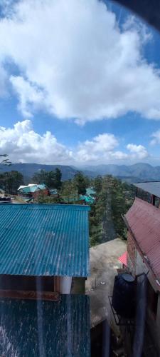vistas a un edificio con techo azul en Shorya Regency en Shimla