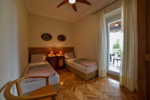 una camera con due letti e una grande finestra di Apartment Villa Oliva a Gostinjac