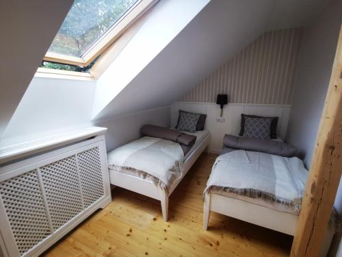 a attic room with two beds and a window at Leśniczówka in Lądek-Zdrój