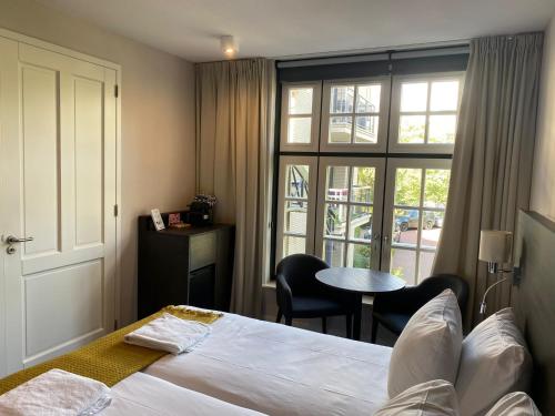 a bedroom with a bed and a table and a window at Mezger Lodges in Domburg