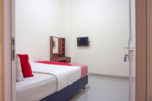 a bedroom with a bed with a mirror and a tv at SUPER OYO Capital O 91790 S1 Residence in Tangerang