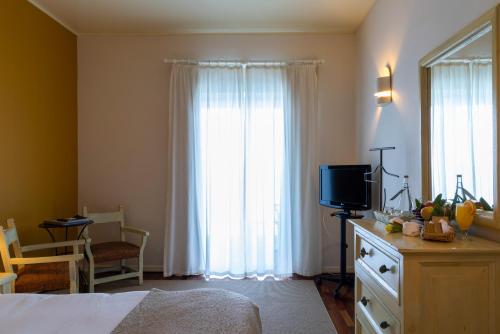 a bedroom with a bed and a tv in a room at Pousada da Ria in Torreira