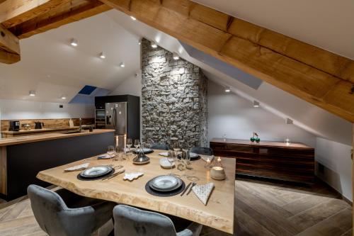 une salle à manger avec une table et des chaises en bois dans l'établissement Mairnaige, luxueux appartement avec sauna, à Gérardmer