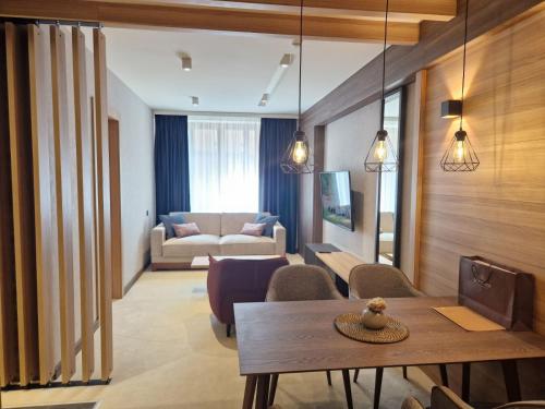 a living room with a table and a couch at Select Lux Woodside Residences & SPA in Kopaonik