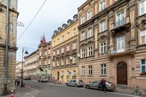 una fila di edifici su una strada di città con le auto di Radziwiłłowska Apartment Cracow Planty by Renters a Cracovia