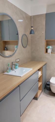 La salle de bains est pourvue d'un lavabo, d'un miroir et de toilettes. dans l'établissement Новые апартаменты Lux, à Chişinău