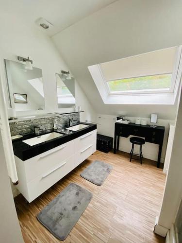 La salle de bains blanche est pourvue d'un lavabo et d'un piano. dans l'établissement LE GRAND LARGE Superbe appartement vue sur mer, à Hautot-sur-Mer