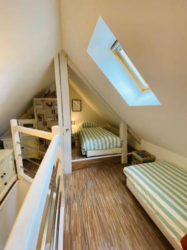 une chambre mansardée avec deux lits superposés et une fenêtre dans l'établissement LE GRAND LARGE Superbe appartement vue sur mer, à Hautot-sur-Mer
