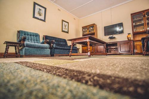 a living room with two chairs and a flat screen tv at Palm villa in Harare