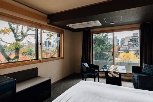 a hotel room with a bed and a desk and a window at Hotel Alza Kyoto in Kyoto