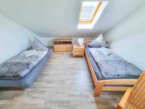 um quarto no sótão com 2 camas e uma janela em PREMIUM Ferienwohnung Michelau em Michelau