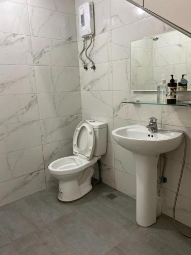 ein weißes Bad mit einem WC und einem Waschbecken in der Unterkunft Donghai Cottage Backpack Inn Suite in Longjing