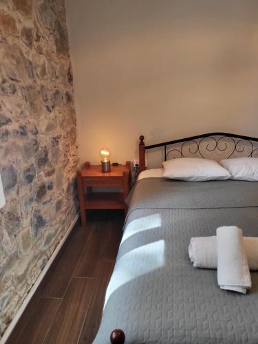 a bedroom with a bed and a stone wall at ThePlatres.Nest in Platres