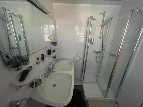 a white bathroom with a sink and a shower at Walchensee-Idyll in Walchensee