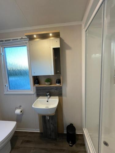 a bathroom with a sink and a shower at PRESTIGE GOLF VILLAGE CARAVAN in Port Seton