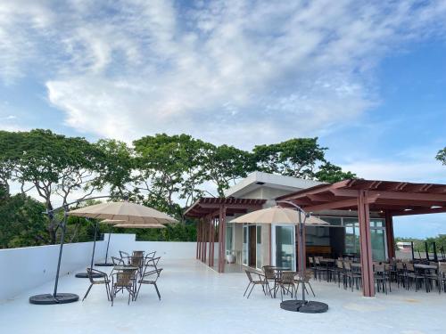 a patio with tables and chairs and umbrellas at Bambu Suites in Puerto Princesa City
