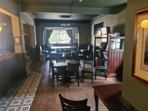 a dining room with tables and chairs and a window at The Hen House in Cannock