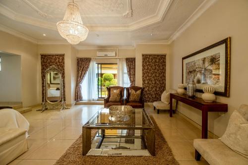 a living room with a couch and a table at The Victoria Falls Deluxe Suites in Victoria Falls