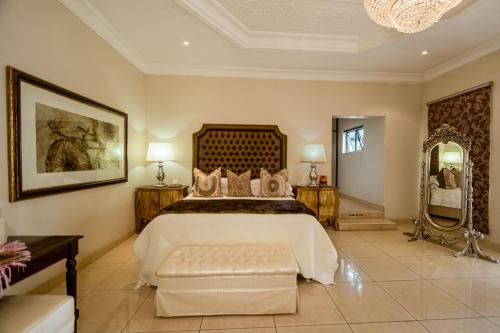 a bedroom with a large bed and a large mirror at The Victoria Falls Deluxe Suites in Victoria Falls