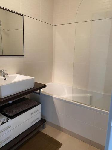 une salle de bain blanche avec un lavabo et une baignoire dans l'établissement PETIT AILLY magnifique logement accès plage à pied, à Varengeville-sur-Mer