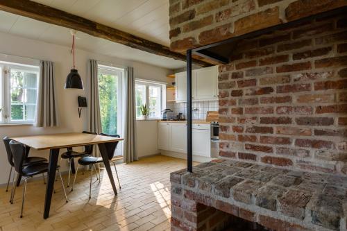 a kitchen with a table and a brick wall at Hindsgavl Slot in Middelfart