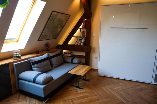 a living room with a couch and a book shelf at Attic Studio Poznań-Jeżyce in Poznań