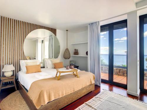 a bedroom with a large bed with a large mirror at Unmei by LovelyStay in Caniço