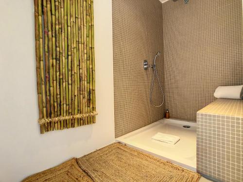 a bathroom with a shower with a sink and a shower curtain at Unmei by LovelyStay in Caniço