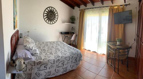 a bedroom with a bed and a table and a window at Eagle Studio in San Miguel de Abona
