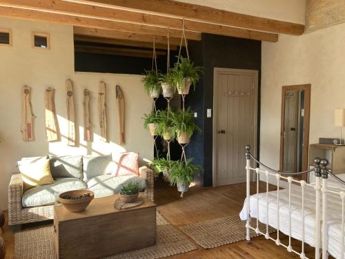 a living room with a couch and potted plants on the wall at No12 in Mansle