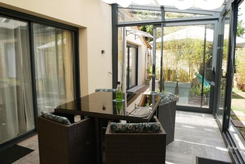 a glass dining room with a table and chairs at Le Cosy Cabarieu in Saint-André-de-Cubzac