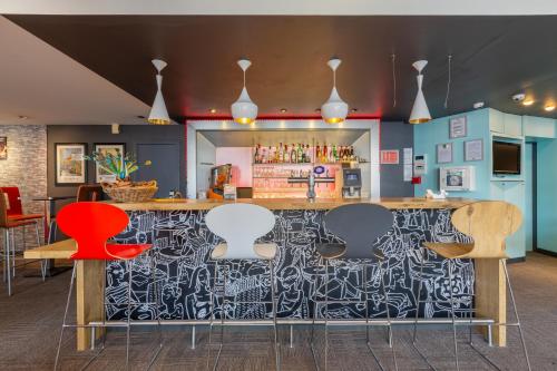 a bar in a restaurant with colorful chairs at B&B HOTEL Chartres Centre Cathédrale 3 étoiles in Chartres